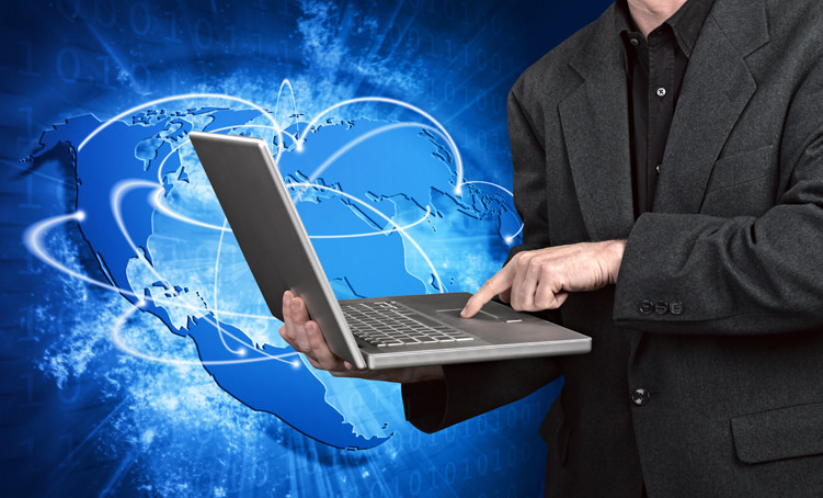 Blue vivid image of globe and man on laptop